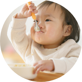 小さなお子様がテーブルで食事している様子